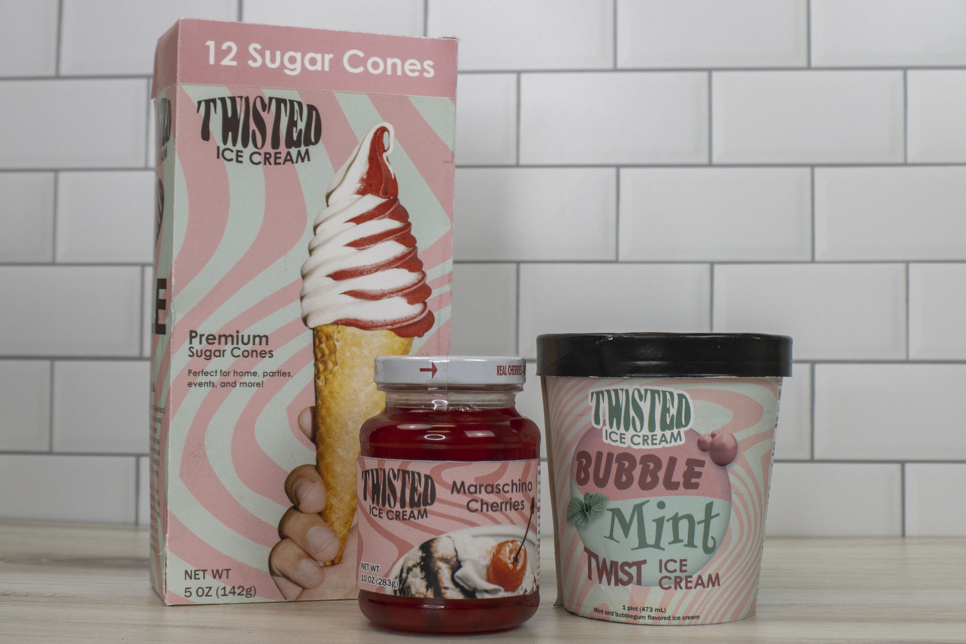 mockup of three pieces of packaging: a box of ice cream cones, a jar of maraschino cherries, and a pint of ice cream